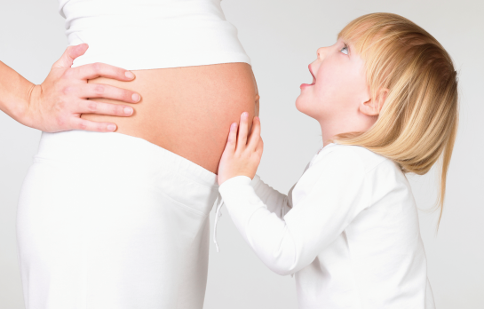 Un enfant tient le ventre de sa mère