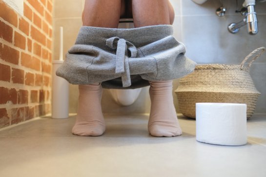 A woman is sitting on the toilet