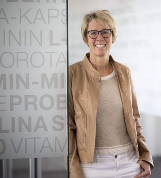 Tanja Zimmermann-Burgerstein angelehnt an einer Glastüre