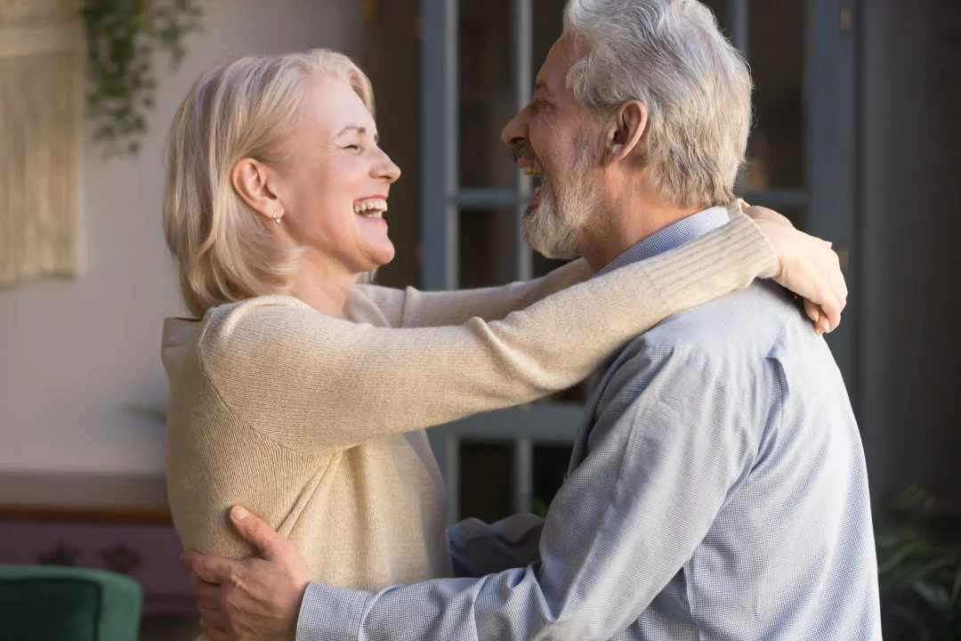 A happy woman dancing with a man in his prime