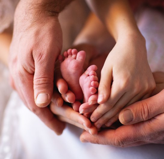 Hands from the parents holding a babies feet