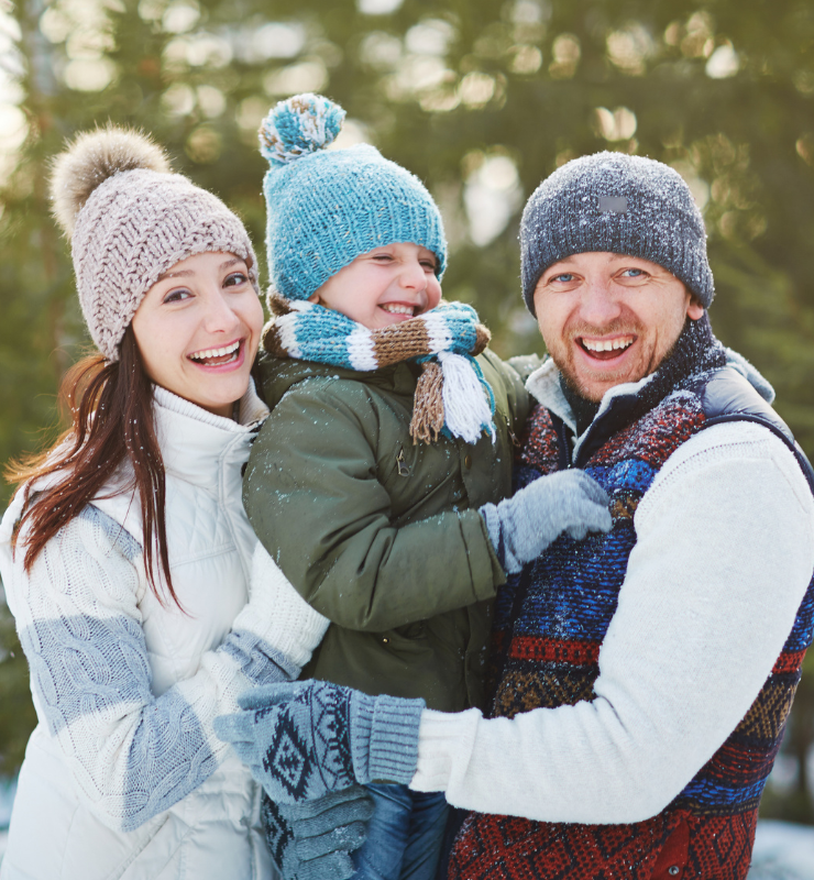 Glückliche Familie mit Kind im Winter – Mikronährstoffe, Vitamine und Mineralstoffe von Burgerstein zur Unterstützung der Familiengesundheit und des Wohlbefindens