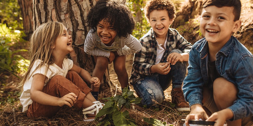 Kinder spielen und lachen im Wald