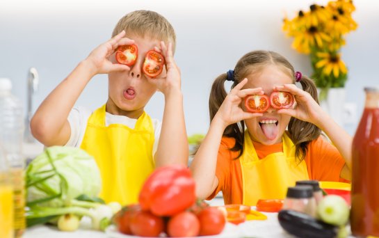 Kinder spielen mit Gemüse in der Küche