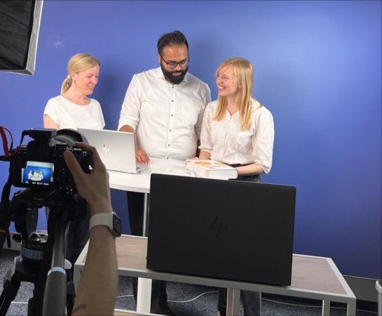 Drei Personen vor einen Bilschirm