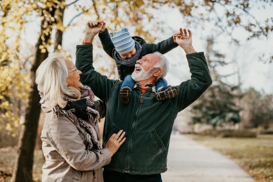Happy grandparents with their grandchild outdoors